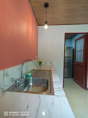 a kitchen with a stainless steel sink and red walls at Guanacaste Azul in Santa Cruz