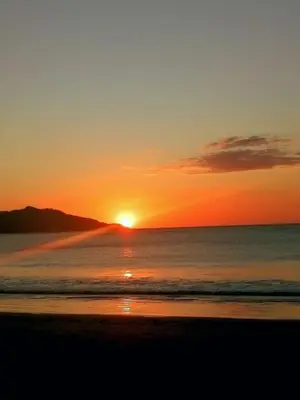 a sunset on a beach with the ocean at Guanacaste Azul in Santa Cruz