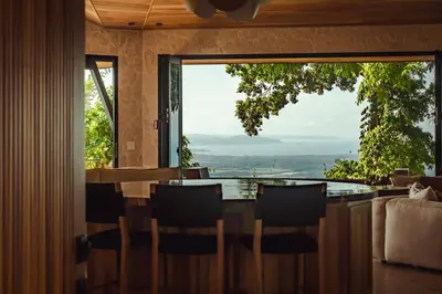 a dining room with a table and a large window at Arbórea Villas in Chontales