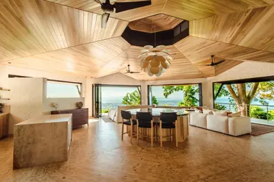 a kitchen and dining room with a large wooden ceiling at Arbórea Villas in Chontales