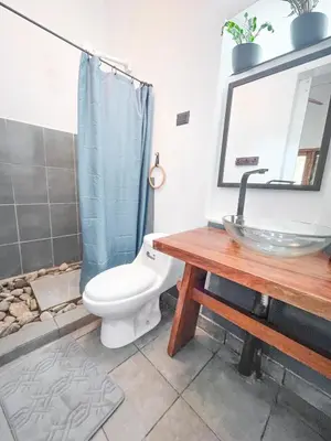 a bathroom with a toilet and a sink and a mirror at Ikiru House in Santa Teresa Beach