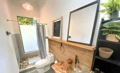 a bathroom with a toilet and a sink at Ikiru House in Santa Teresa Beach