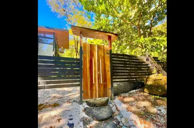 a wooden entrance to a house with a fence at Ikiru House in Santa Teresa Beach
