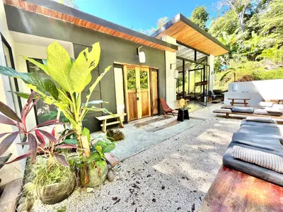 a house with a patio with plants in front of it at Ikiru House in Santa Teresa Beach