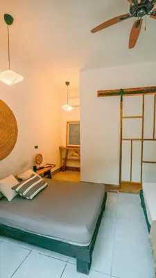 a bedroom with a bed and a ceiling fan at Ikiru House in Santa Teresa Beach