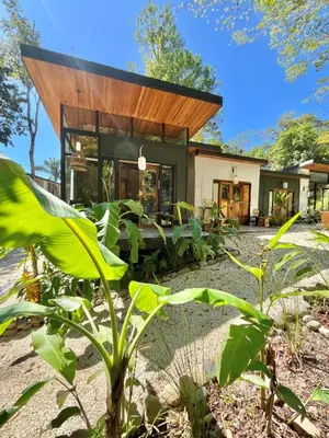 a modern house with a wooden roof at Ikiru House in Santa Teresa Beach