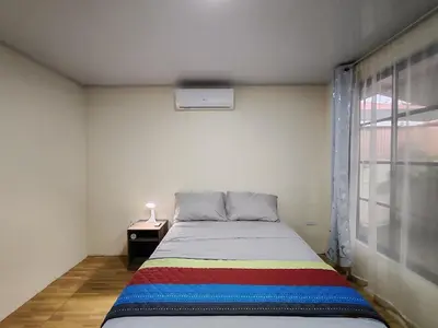 a bedroom with a bed with a rainbow blanket at Villas Los Titos in La Fortuna in San Francisco