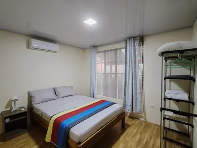 a bedroom with a bed with a rainbow blanket at Villas Los Titos in La Fortuna in San Francisco