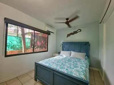 a bedroom with a blue bed and a window at A little bit of Paradise Ground Floor Studio in Coco