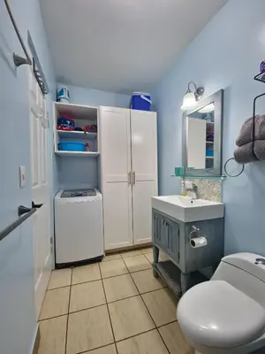 a blue bathroom with a toilet and a sink at A little bit of Paradise Ground Floor Studio in Coco
