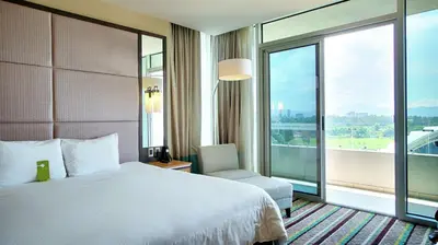 a hotel room with a bed and a large window at Hilton Garden Inn San Jose La Sabana, Costa Rica in San José
