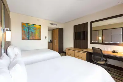 a hotel room with two beds and a desk at Hilton Garden Inn San Jose La Sabana, Costa Rica in San José