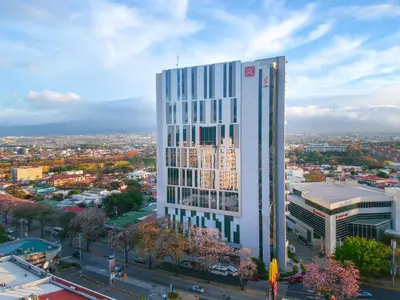 a tall white building in the middle of a city at Hilton Garden Inn San Jose La Sabana, Costa Rica in San José