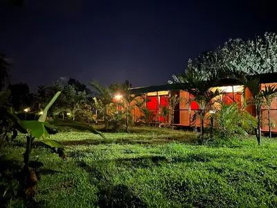 a building in the middle of a field at night at Sloffee house in Guayabal