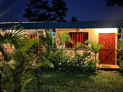 a house with a red door and some plants at Sloffee house in Guayabal
