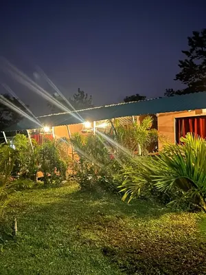 a house with lights in a yard at night at Sloffee house in Guayabal