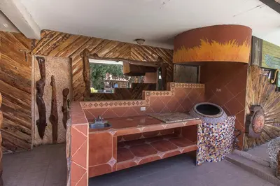 a kitchen with a stove in a room with wooden walls at Casa Antigua Hotel in Alajuela City