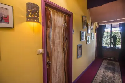a room with a door and a hallway with pictures at Casa Antigua Hotel in Alajuela City