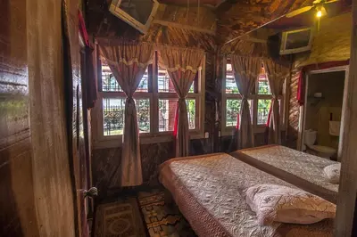 a bedroom with a bed in a room with windows at Casa Antigua Hotel in Alajuela City