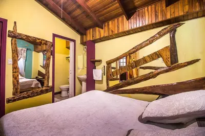 a bedroom with a large bed and a mirror at Casa Antigua Hotel in Alajuela City