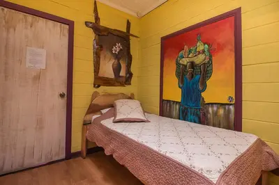 a bedroom with a bed and a painting on the wall at Casa Antigua Hotel in Alajuela City