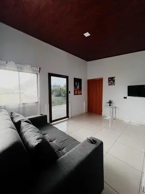 a living room with a couch and a large window at Teyú Green Cottage in Cuatro Esquinas