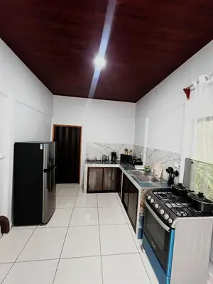 a kitchen with a black refrigerator and a stove at Teyú Green Cottage in Cuatro Esquinas
