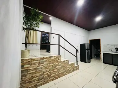 a staircase in a living room with a kitchen at Teyú Green Cottage in Cuatro Esquinas