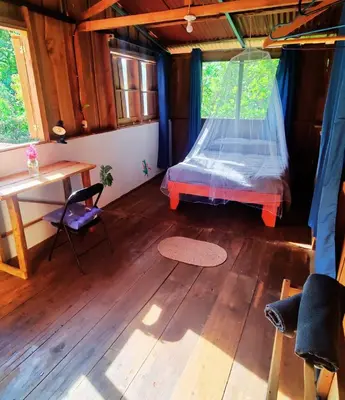 a room with a bed and a desk in a house at Wild Nest Chirripo in Rivas