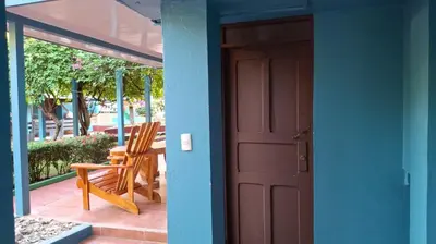 a door leading to a patio with a table and chairs at Hotel Marielos Tamarindo in Tamarindo