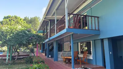 a blue building with a table and a balcony at Hotel Marielos Tamarindo in Tamarindo