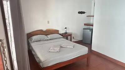 a bedroom with a bed with a towel on it at Hotel Marielos Tamarindo in Tamarindo
