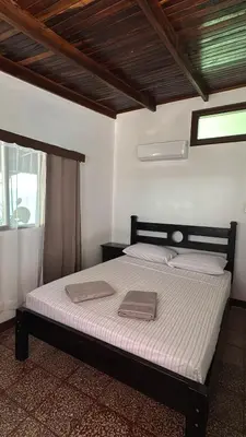 a bedroom with a bed with two towels on it at Hotel Marielos Tamarindo in Tamarindo