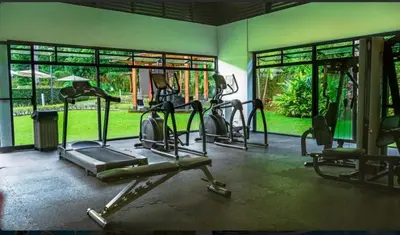 a gym with several tread machines in a room at Casa Coral tu refugio ideal in Herradura