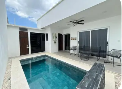 a swimming pool in a house with a ceiling fan at Casa Coral tu refugio ideal in Herradura