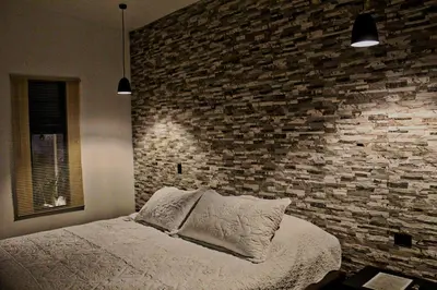 a bedroom with a brick wall and a bed at Fortuna Tropical Loft in Fortuna