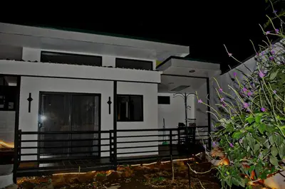 a small white house with a fence in front of it at Fortuna Tropical Loft in Fortuna