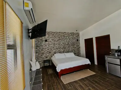 a bedroom with a bed and a brick wall at Fortuna Tropical Loft in Fortuna