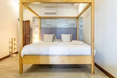 a bed with a wooden frame in a bedroom at Colinas Tinamastes in San Isidro