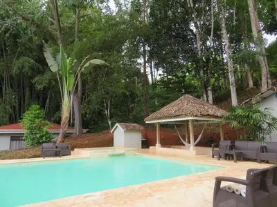 a swimming pool with chairs and a gazebo at Colinas Tinamastes in San Isidro
