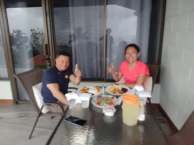 a man and woman sitting at a table with food at Colinas Tinamastes in San Isidro