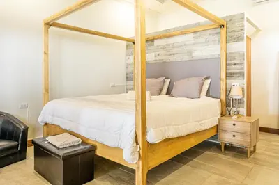 a bedroom with a wooden canopy bed in a room at Colinas Tinamastes in San Isidro