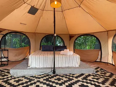 a bed in a tent with four windows at SurFreak Backyard Glamping CoWorking Experience in Mal País