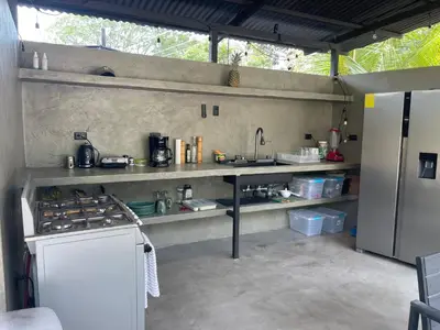 a kitchen with a stove and a sink and a refrigerator at SurFreak Backyard Glamping CoWorking Experience in Mal País