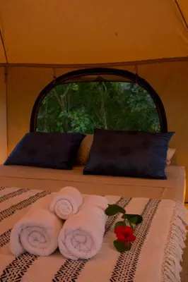 a group of towels on a bed with a window at SurFreak Backyard Glamping CoWorking Experience in Mal País