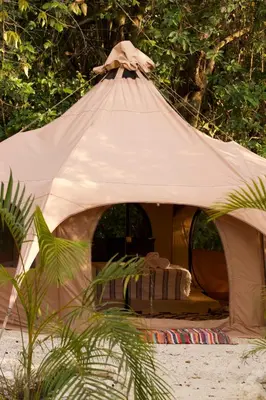 a tent on the beach with a bed in it at SurFreak Backyard Glamping CoWorking Experience in Mal País
