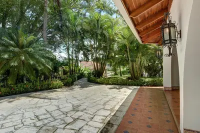 a courtyard with palm trees and a walkway at El Castillo de Esparza in Esparza