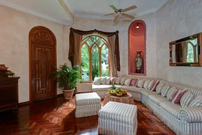 a living room with white furniture and a ceiling fan at El Castillo de Esparza in Esparza