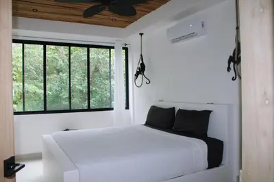 a bedroom with a white bed and a window at Nosara Verde in Nicoya