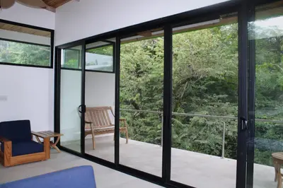 a room with glass doors and a chair at Nosara Verde in Nicoya